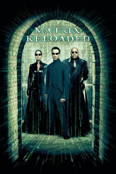 Three people in dark clothing and sunglasses stand dramatically in a line and look towards camera at the end of a brick corridor. The corridor is lit in an unnatural green sepiatone, with streaks of bright green code flowing down the walls and across the floor. The character front and center in the lineup is Neo, a white man with short black hair wearing a long black coat, portrayed by Keanu Reeves. The character to Neo's left is Trinity, a white woman with short black hair wearing a latex trenchcoat, portrayed by Carrie-Anne Moss. The character to Neo's right is Morpheus, a bald black man wearing a suit and tie beneath a trenchcoat, portrayed by Laurence Fishburne. The film's title, "Matrix Reloaded," appears at the top of the poster in jagged glowing green text.